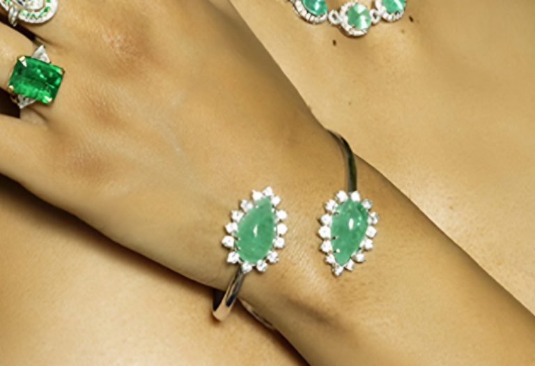Bangle with two pear-shaped cabochon emeralds framed in diamonds