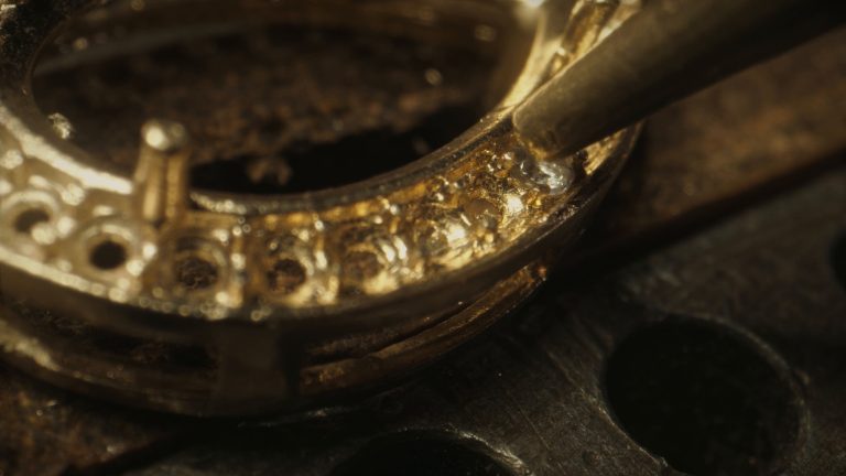 Diamonds being set by hand into a gold ring