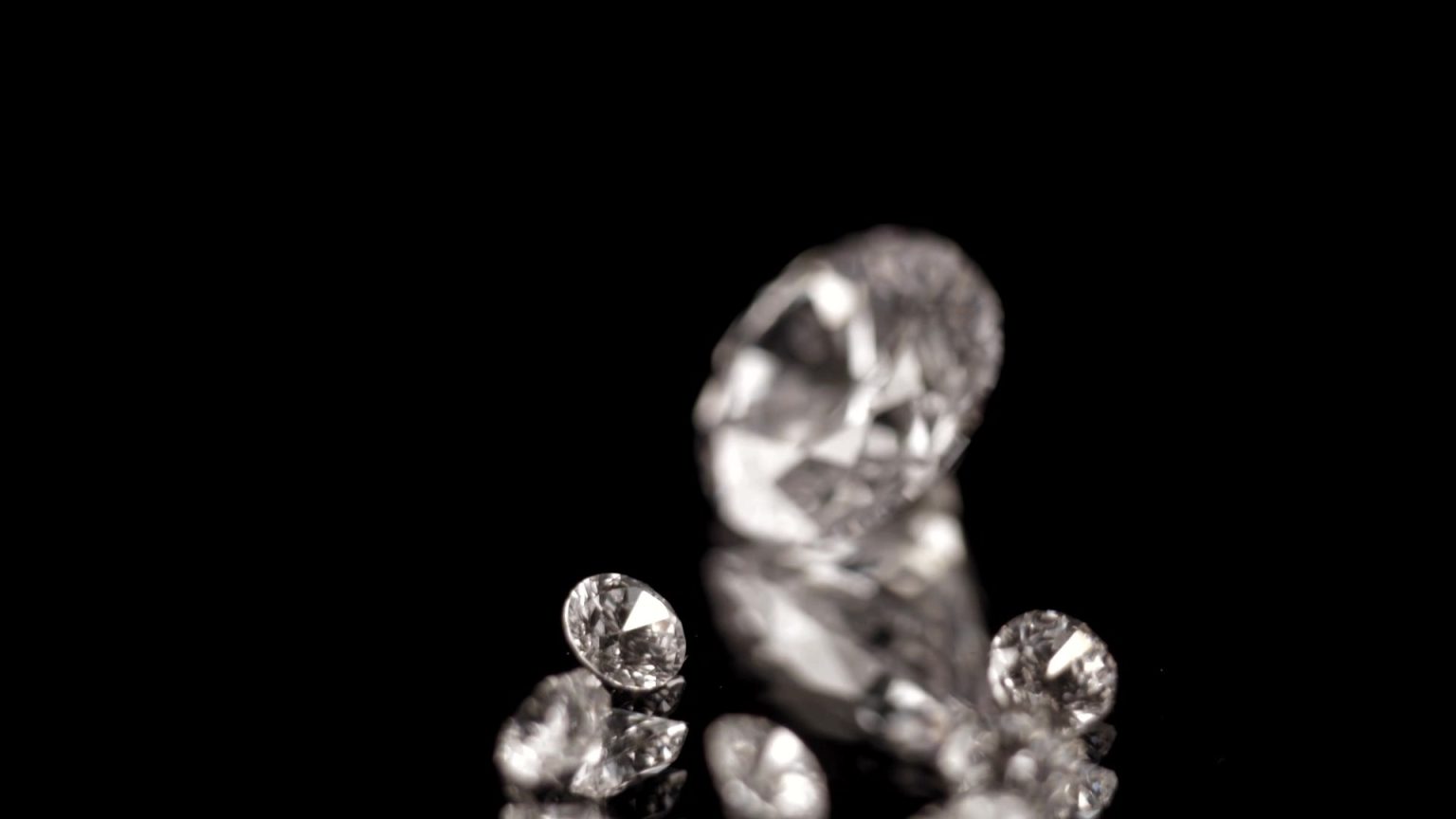 Loose brilliant-cut diamonds on black glass