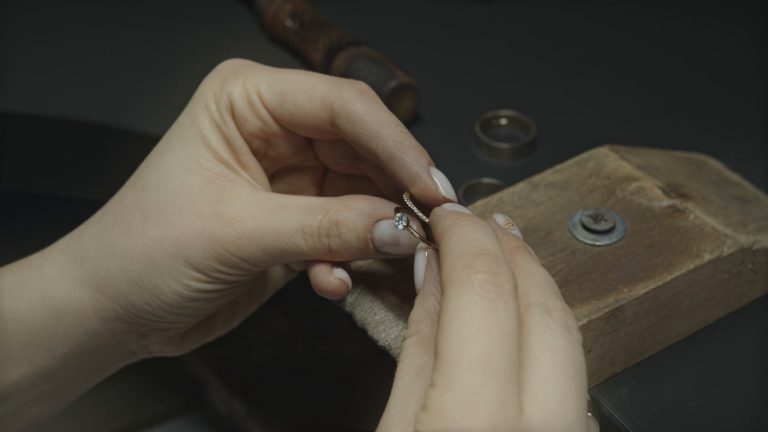 A jeweler holding a diamond ring at the bench